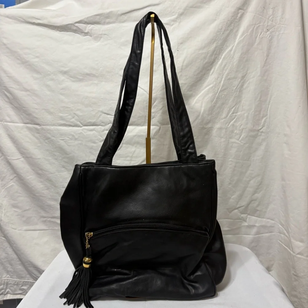 Black tote bag with a tassel accent. - Picture 2 of 12